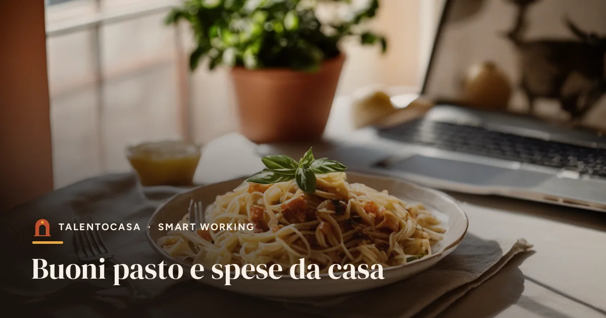 Piatto di pasta sulla scrivania di casa accanto a un portatile
