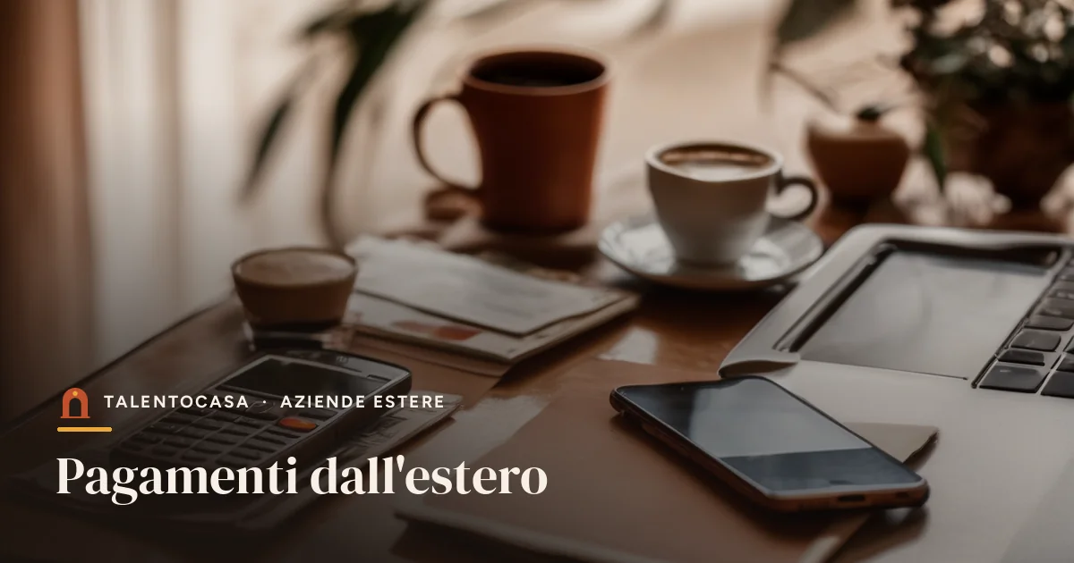 Smartphone e carte bancarie accanto a un portatile e a una tazza di caffè